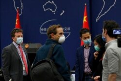 FILE - The New York Times Beijing-based correspondent Steven Lee Myers, left, chats with other foreign journalists after a daily briefing at the Ministry of Foreign Affairs office in Beijing, China, March 18, 2020.