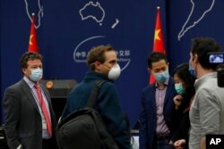 FILE - The New York Times Beijing-based correspondent Steven Lee Myers, left, chats with other foreign journalists after a daily briefing at the Ministry of Foreign Affairs office in Beijing, China, March 18, 2020.