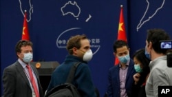 The New York Times Beijing based correspondent Steven Lee Myers, left, chats with other foreign journalists after a daily briefing at the Ministry of Foreign Affairs office in Beijing, March 18, 2020.