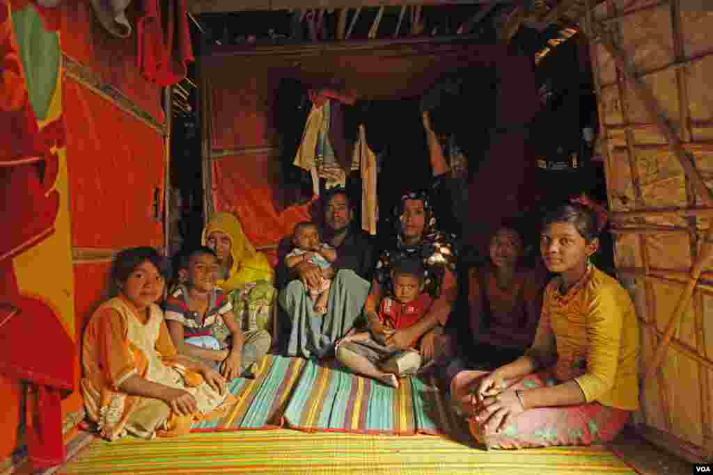 Abu Sayod and his wife, Anuwara Begum, are surrounded with their children in the living room that doubles as the bedroom of their shelter at Kutupalong refugee camp in Cox&rsquo;s Bazar Feb. 13, 2020. The children are from left, Aru Juma, Anayet Husson, Aziz Fatima, Saiful Islam, Jahed Husson, Tasmin Fatima and Nur Fatima. Abu Sayod worked as a farmer in the Rakhine state of Myanmar until their escape to Bangladesh in 2017. (Hai Do/VOA)