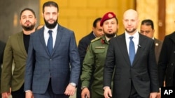 Syria's de facto leader Ahmad al-Sharaa, foreground left, formerly known as Abu Mohammed al-Golani, meets with Walid Ellafi, right, Libyan minister of state for communication and political affairs, in the presidential palace in Damascus, Syria, Dec. 28, 2024.