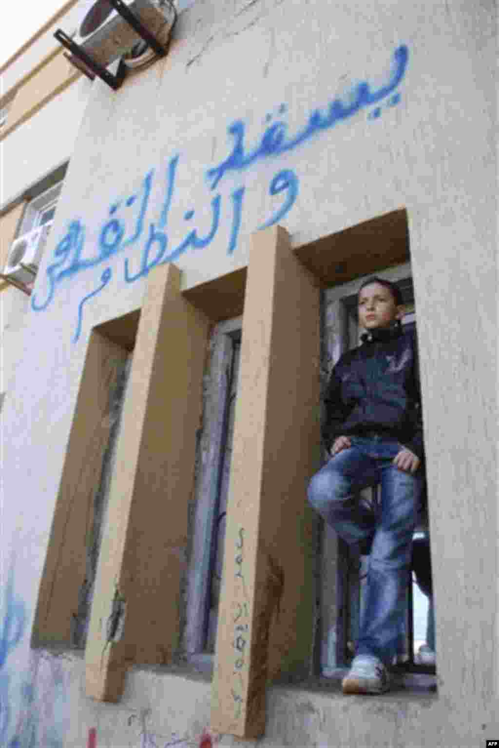 This photograph, obtained by The Associated Press outside Libya and taken by an individual not employed by AP, shows a scene from recent days' unrest in Benghazi, Libya. The graffiti in Arabic reads "Down with Gadhafi and the regime". (AP Photo) EDITOR'S 