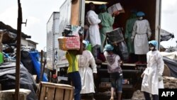 Des employés du ministère de la Santé chargent un camion après avoir vidé les magasins vendant de faux médicaments lors d'un raid au marché d'Adjamé à Abidjan, le 3 mai 2017.