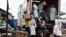 Des employés du ministère de la Santé chargent un camion après avoir vidé les magasins vendant de faux médicaments lors d'un raid au marché d'Adjamé à Abidjan, le 3 mai 2017.