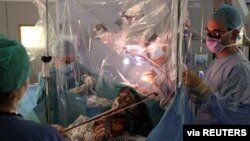 Patient Dagmar Turner, 53, plays violin while surgeons remove her brain tumor at King's College Hospital in London, Jan. 31, 2020, in this handout image obtained by Reuters on Feb. 19, 2020.