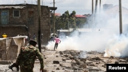 Un policier anti-émeute disperse des habitants lors d'un affrontement au sujet de la démolition de maisons dans les quartiers informels de Mukuru Kwa Njenga pour ouvrir la voie à la construction de l'autoroute de Nairobi avec zone industrielle à Nairobi, le 27 décembre 2021.