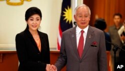 Thai Prime Minister Yingluck Shinawatra, left, and her Malaysian counterpart Najib Razak pose for photographers after their joint press conference at the latter's office in Putrajaya, Malaysia, February 28, 2013.