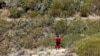 FILE - A volunteer firefighter searches for a missing British teenager in the Juan Lopez ravine near Masca, on the island of Tenerife, Spain, June 29, 2024. The body of Jay Slater was found on July 15, 2024.