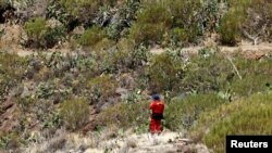 FILE - A volunteer firefighter searches for a missing British teenager in the Juan Lopez ravine near Masca, on the island of Tenerife, Spain, June 29, 2024. The body of Jay Slater was found on July 15, 2024.