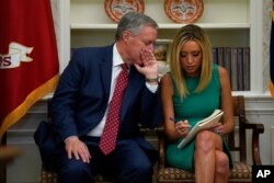 FILE - White House chief of staff Mark Meadows speaks with White House press secretary Kayleigh McEnany in the Oval Office of the White House, April 29, 2020, in Washington.