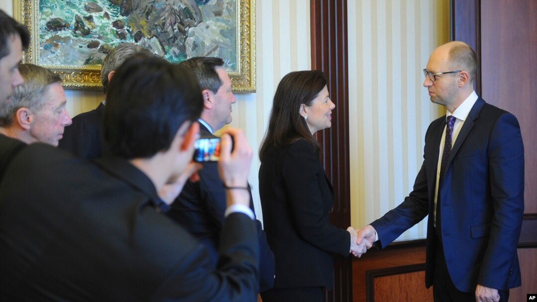 Ukrainian Prime Minister Arseniy Yatsenyuk (r) shakes hands with U.S. Senator Kelly Ayotte in Kyiv, March 23, 2014.