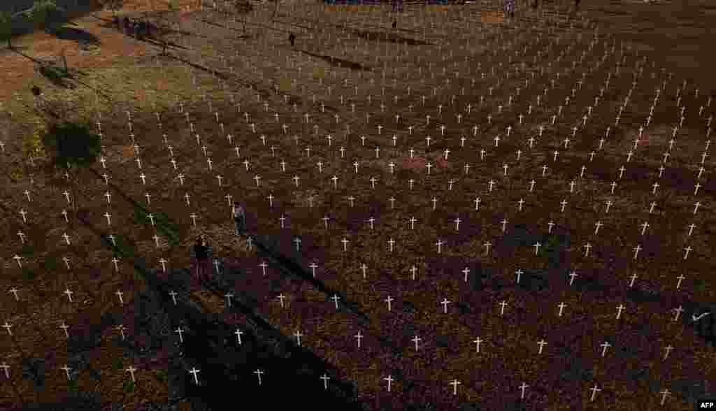 Crosses are placed in hour of the people who died of COVID-19 in front of the National Congress in Brasilia, during a protest against Brazil&#39;s President Jair Bolsonaro.