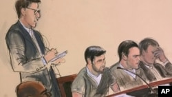 In this court room drawing, an interpreter, stands as he takes notes while defendant Efrain Campo, center left, makes a statement in Spanish to the judge during his sentencing hearing in New York, Dec. 14, 2017. The interpreter will translate the statement and read it back to the judge. Seated at center right is co-defendant Francisco Flores.
