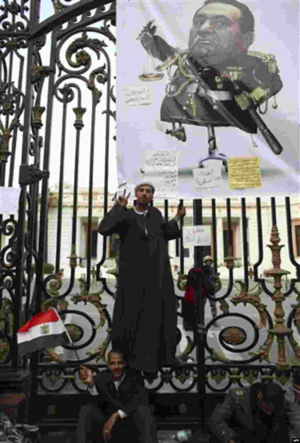 An anti-government protester gestures as he poses for a picture outside the Egyptian Parliament in Cairo, Egypt, Wednesday, Feb. 9, 2011. Around 2,000 protesters waved huge flags outside the parliament, several blocks from Tahrir Square, where they moved 