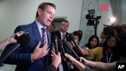 FILE - Rep. Eric Swalwell, D-Calif., pauses to speak with reporters on Capitol Hill in Washington, July 16, 2018.