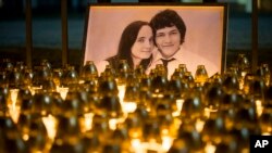 Light tributes are placed during a silent protest in memory of murdered journalist Jan Kuciak and his girlfriend, Martina Kusnirova, seen in the photograph, in Bratislava, Slovakia, Feb. 28, 2018. 