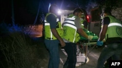 Rescuers evacuate a body pulled from the rubble of a Civil Defense emergency center which was hit in an overnight Israeli airstrike in the southern Lebanese village of Derdghaiya, early Oct. 10, 2024. 