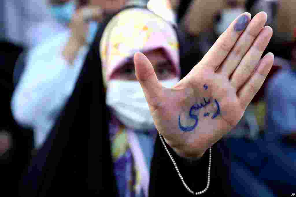 이란 대통령 선거를 앞두고 테헤란에서 열린 에브라힘 라이시 후보 지지 유세에서 한 여성이 &#39;라이시&#39;를 쓴 손을 들어보였다.