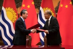 FILE - Chinese Foreign Minister Wang Yi and Kiribati's President Taneti Maamau shake hands during a signing ceremony at the Great Hall of the People in Beijing, China, Jan. 6, 2020.