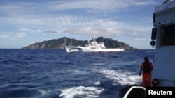 Sebuah kapal penjaga perairan Jepang (tengah) berupaya menghalangi kapal penjaga perairan Taiwan yang mengawal kapal nelayannya mendekat ke kepulauan sengketa di Laut Cina Timur (4/7). Kepulauan ini disebut Senkaku (Jepang), Diaoyutai / Diaoyo (Tiongkok) 