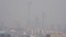 The Beijing skyline is seen in smog ahead of Chinese Lunar New Year, Feb. 13, 2018. A slight slowing in the Chinese economy is linked to the new year holiday and stricter pollution measures.