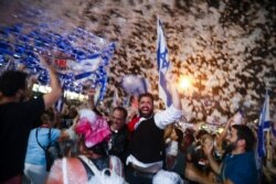People celebrate the swearing-in of the a new government, in Tel Aviv, Israel, June 13, 2021.