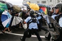 Police try to disperse protesters near a flag raising ceremony for the anniversary of Hong Kong handover to China, in Hong Kong, July 01, 2019.