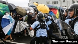 Police try to disperse protesters near a flag-raising ceremony for the anniversary of Hong Kong handover to China in Hong Kong, July 1, 2019.