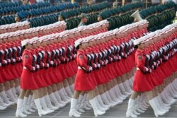 FILE - Militia members and soldiers of People's Liberation Army (PLA) march past Tiananmen Square during a rehearsal before a military parade marking the 70th founding anniversary of People's Republic of China, on its National Day in Beijing.