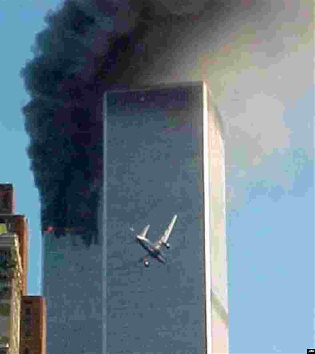 FILE - In this Sept. 11, 2001 file photo, United Airlines Flight 175 approaches the south tower of the World Trade Center in New York shortly before collision as smoke billows from the north tower. (AP Photo/Carmen Taylor)