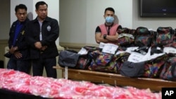 Members of the National Bureau of Investigation stand guard near bags containing nearly one metric ton of seized methamphetamine during a press conference in Manila, Dec. 27, 2016.