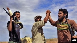 Libyan revolutionary fighters react during an attack on the city of Sirte, Libya, October 6, 2011.