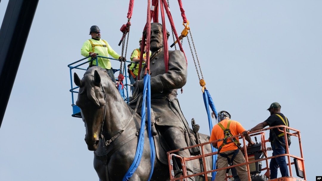 Crews remove one of the country's largest remaining monuments to the Confederacy, a towering statue of Confederate General Robert E. Lee on Monument Avenue, Sept. 8, 2021, in Richmond, Va.