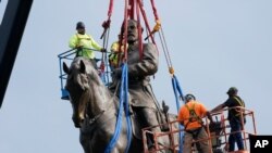 Crews remove one of the country's largest remaining monuments to the Confederacy, a towering statue of Confederate General Robert E. Lee on Monument Avenue, Sept. 8, 2021, in Richmond, Va.