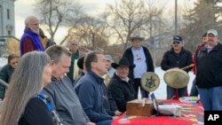 Montana Gov. Steve Bullock, third from left, speaks at an event marking the federal government’s formal recognition of the Little Shell Tribe of Chippewa Indians Friday, Dec. 20, 2019, at the state capitol in Helena, Mont. Congress passed a measure…