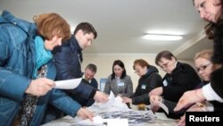 Members of a local electoral commission count votes following a parliamentary election in Chisinau, Moldova, Feb. 24, 2019. 