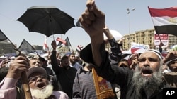 People attend Friday prayers in Tahrir Square in Cairo. Tens of thousands of Egyptians demanded on Friday that their military rulers stick to a pledge to hand over power by mid-year after a row over who can run in the presidential election raised doubts a