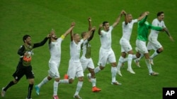 Members of the Algerian soccer team celebrate on the pitch after beating South Korea 4-2 on June 22, 2014.