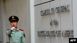 (FILES) This file photo taken on September 18, 2012 shows a Chinese paramilitary policeman gesturing to photographers at the entrance to the US consulate in Chengdu, southwest China's Sichuan province. - China said on July 24, 2020 it had revoked…