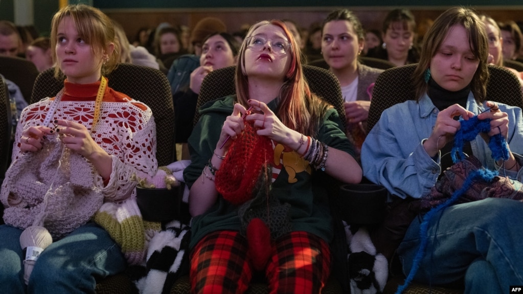 Women knit during the projection of the movie 'The Devil Wears Prada' at the Votive Cinema in Vienna, Austria, on February 16, 2025. (Photo by JOE KLAMAR / AFP)