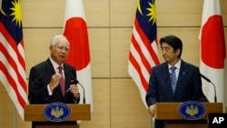 Perdana Menteri Malaysia Najib Razak (kiri) dan Perdana Menteri Jepang Shinzo Abe dalam konferensi pers bersama di Tokyo (25/5). (AP/Issei Kato. pool)