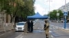 FILE - Uzbek law enforcement officers check documents at a checkpoint in Tashkent, Uzbekistan, April 9, 2020.