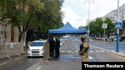 FILE - Uzbek law enforcement officers check documents at a checkpoint in Tashkent, Uzbekistan, April 9, 2020.