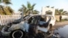 FILE - The day after the deaths, a person looks at a vehicle where seven aid workers with World Central Kitchen were killed in an Israeli airstrike in the Gaza Strip on April 1, 2024.