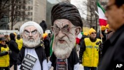 FILE - Two people dressed as Iranian President Hassan Rouhani, left, and Iran's supreme Leader Ayatollah Ali Khamenei, right, participate in an Organization of Iranian-American Communities rally in Washington, March 8, 2019.