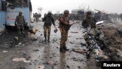 Tentara India memeriksa lokasi ledakan bom mobil di Lethpora, Kashmir selatan yang menewaskan 10 tentara India, Kamis (14/10). 