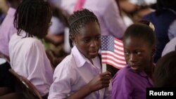 Une étudiante tient un drapeau américain avant l'arrivée de la première dame des États-Unis, Michelle Obama, au collège Martin Luther King, entièrement féminin, à Dakar, le 27 juin 2013. (REUTERS/Joe Penney)