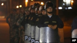 FILE - Police officers stand guard near Ecuador's border with Peru, in Tumbes, Peru, June 15, 2019. Ecuador will launch a new prevention and assistance plan focused on sexual and labor exploitation victims, an official has announced.