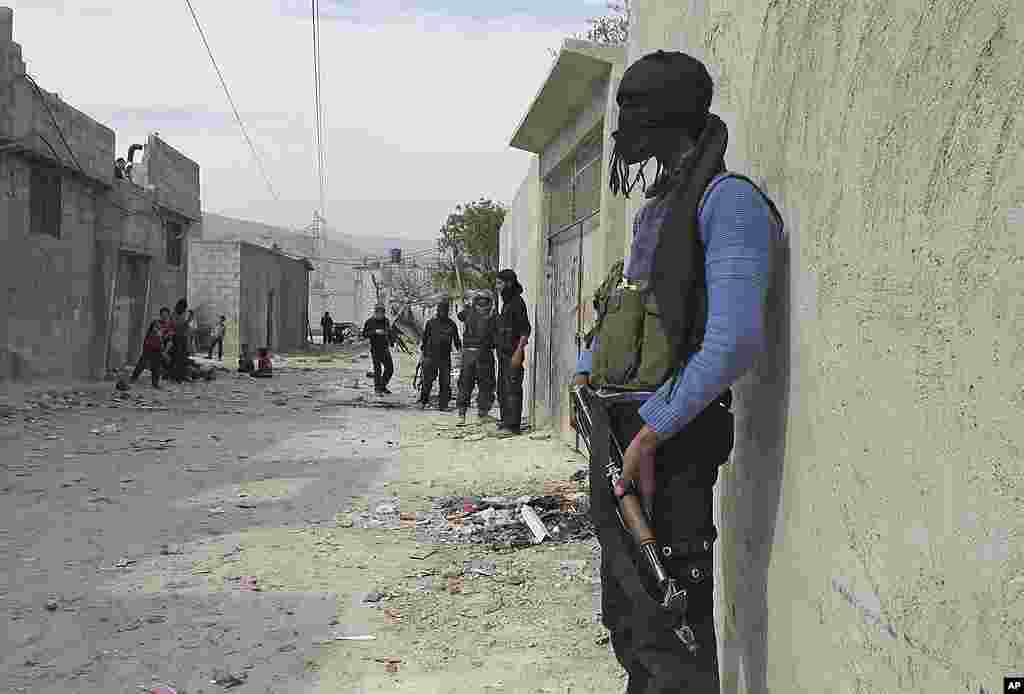 In this Sunday, April 1, 2012 photo, A Free Syrian Army fighter stands guard in a neighborhood in Damascus. (AP)