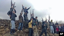 Syrian soldiers who defected to join the Free Syrian Army are seen among demonstrators during a protest against Syria's President Bashar al-Assad in Kafranbel near Idlib January 29, 2012.